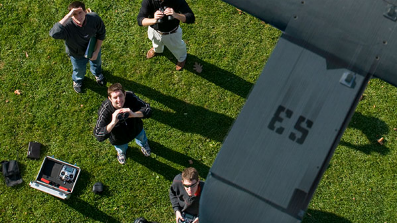 Students look up at a drone