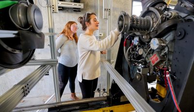 students looking at an engine up close