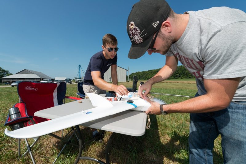 Hunter McClelland and Charles Watson prepare a small fixed-wing UAS for a wind-sensing mission.